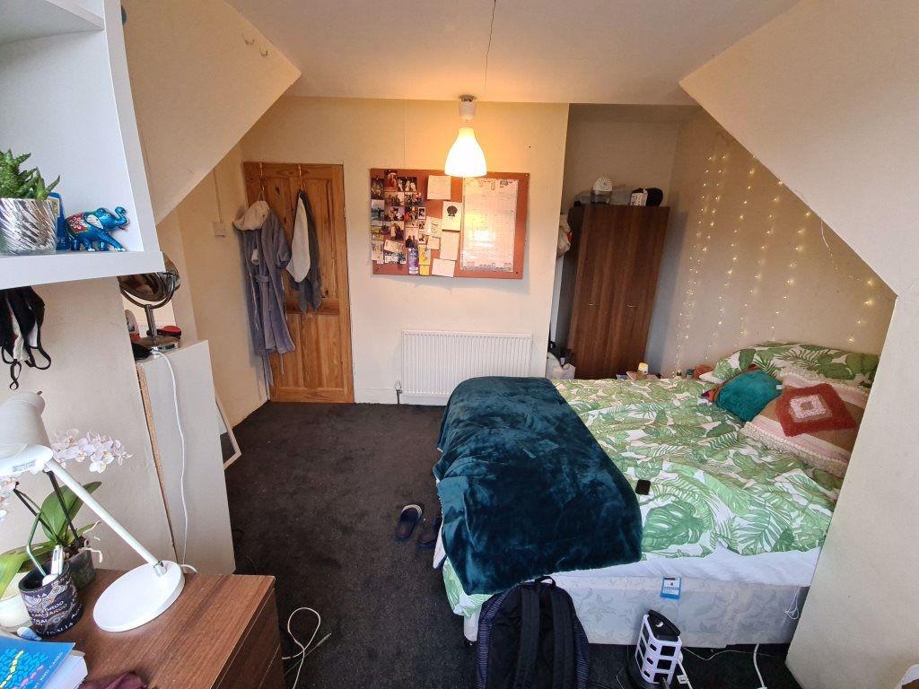 A cozy single bedroom featuring a neatly made b...