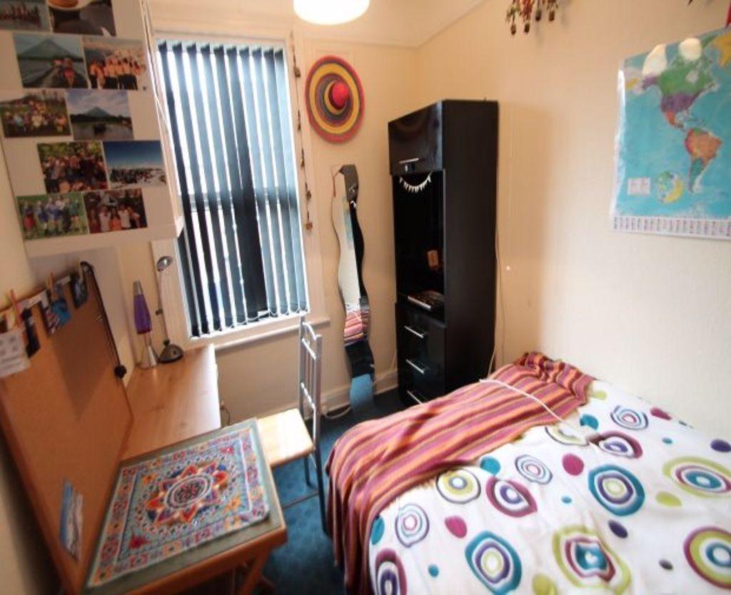 A cozy bedroom featuring a single bed with a co...