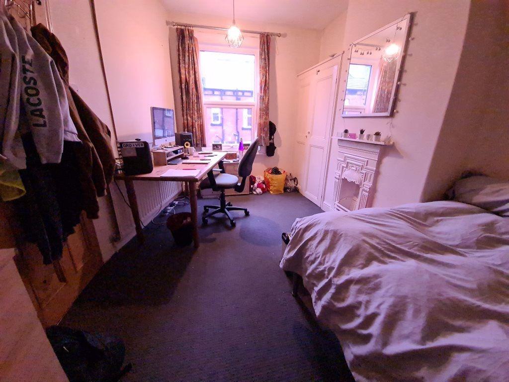 A cozy bedroom featuring a large bed, a study d...