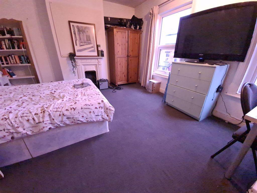 A cozy bedroom featuring a comfortable bed, amp...