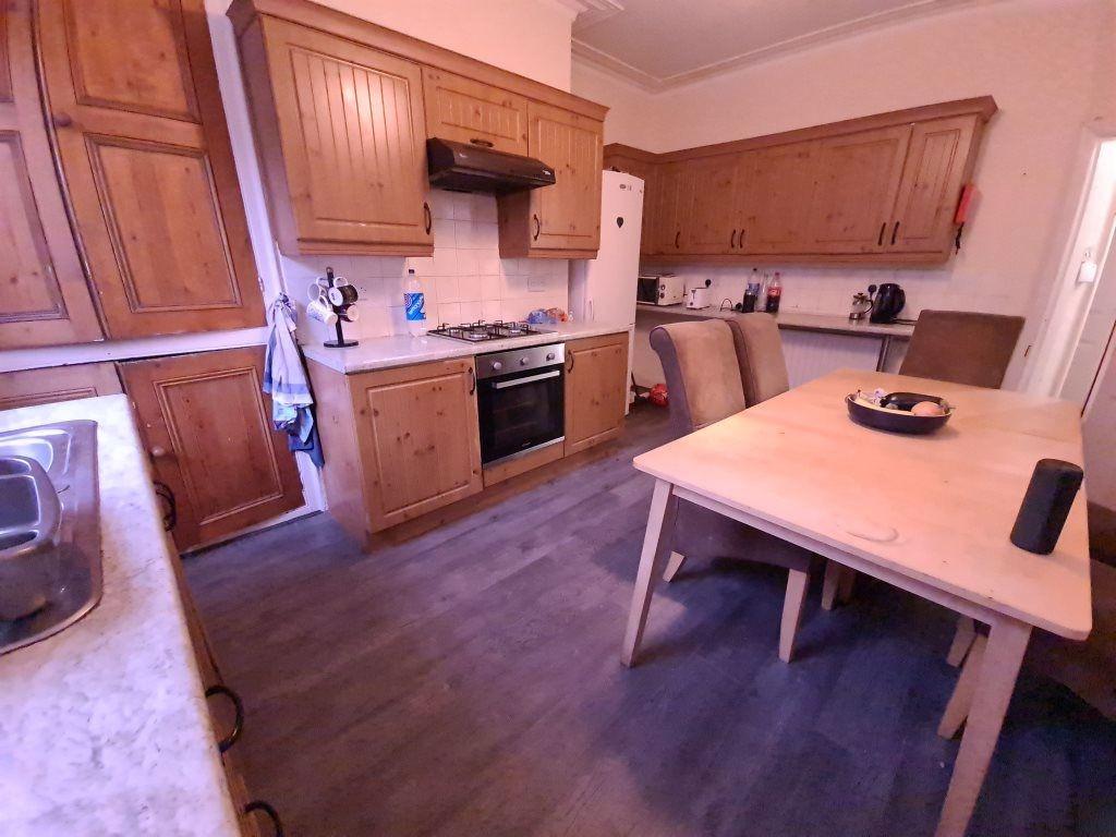 A well-maintained kitchen with wooden cabinets,...