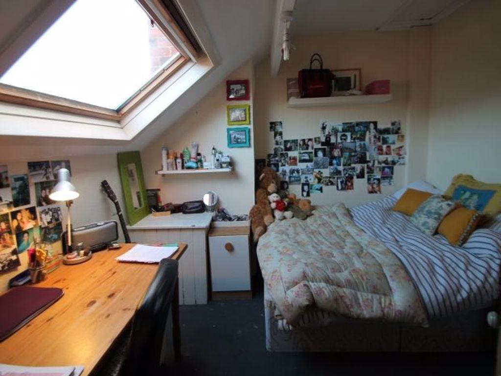 A cozy bedroom with a skylight window providing...
