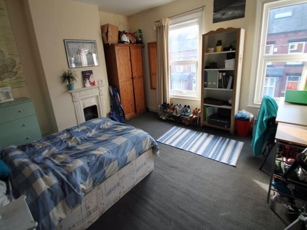 A cozy, well-lit bedroom with a single bed, nat...