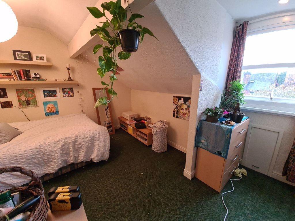 A cozy bedroom featuring a comfortable bed, pot...