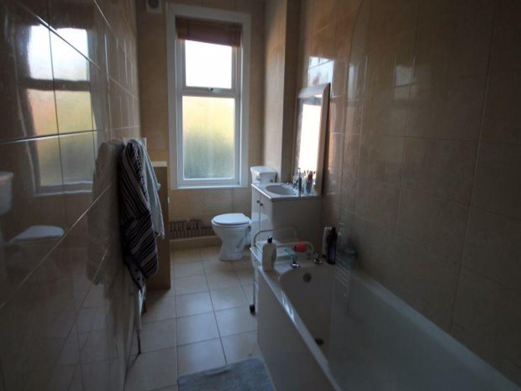 A clean and well-lit bathroom featuring a batht...
