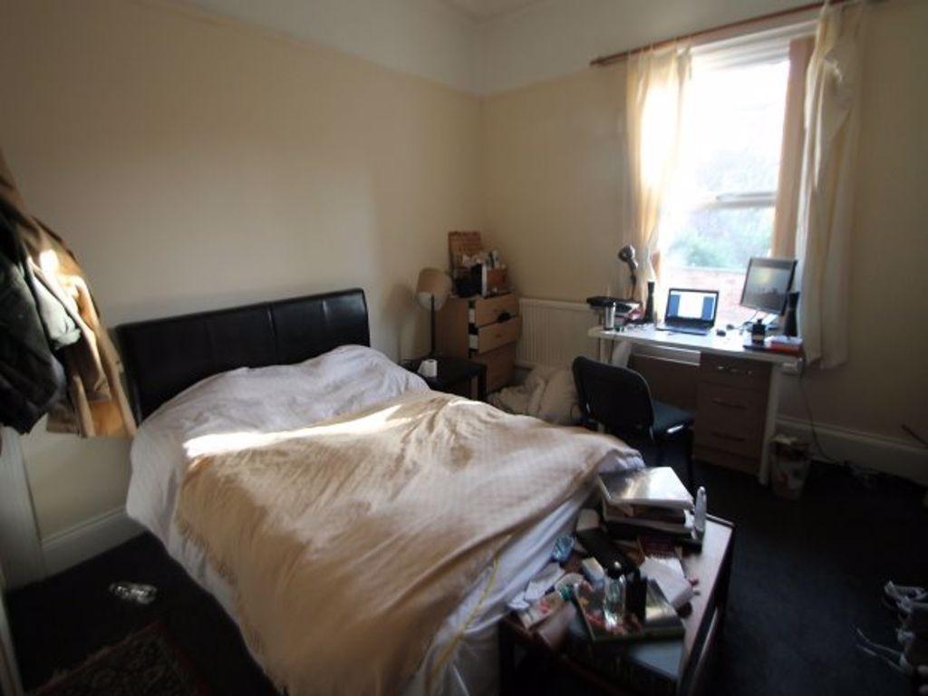 A cozy bedroom featuring a double bed, a window...
