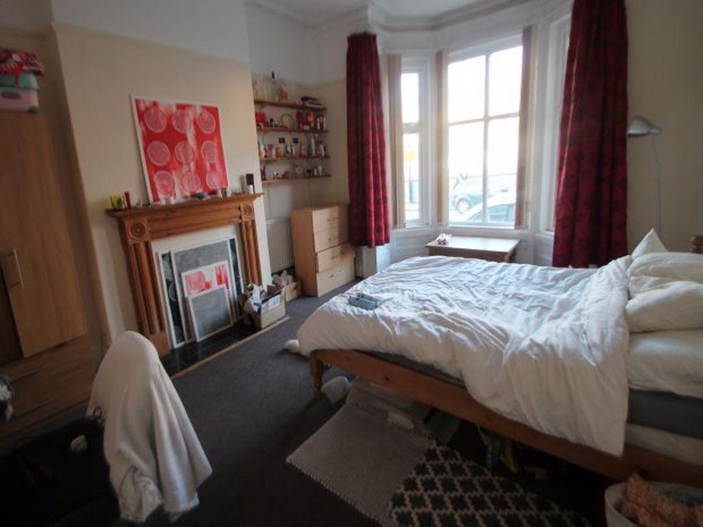 A bright and tidy bedroom featuring a comfortab...