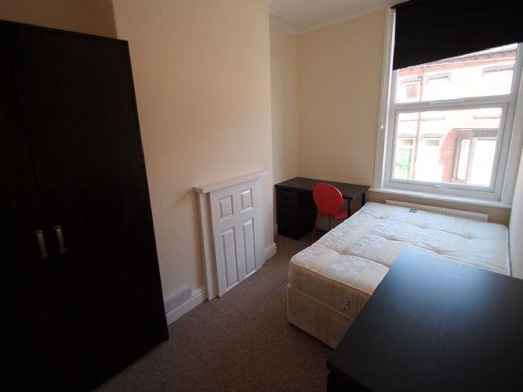 A cozy single bedroom featuring a bed near a la...