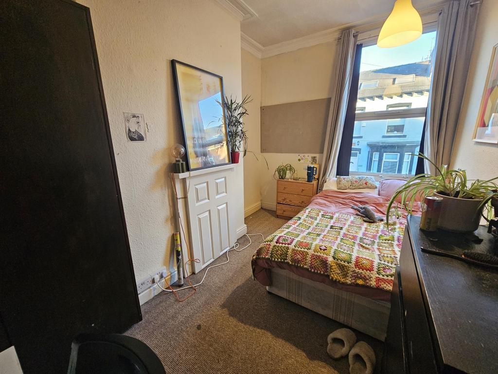Bright, neatly arranged bedroom with a comforta...