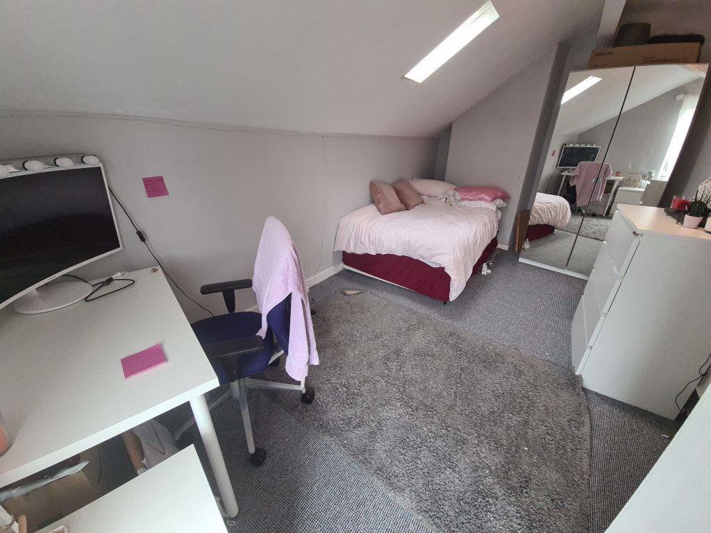 A bright and cozy bedroom featuring a neatly ma...