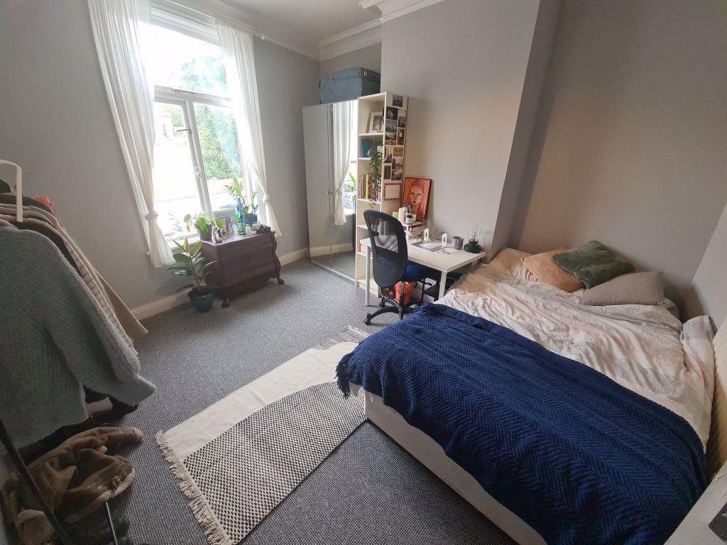 A cozy and well-lit bedroom featuring a comfort...
