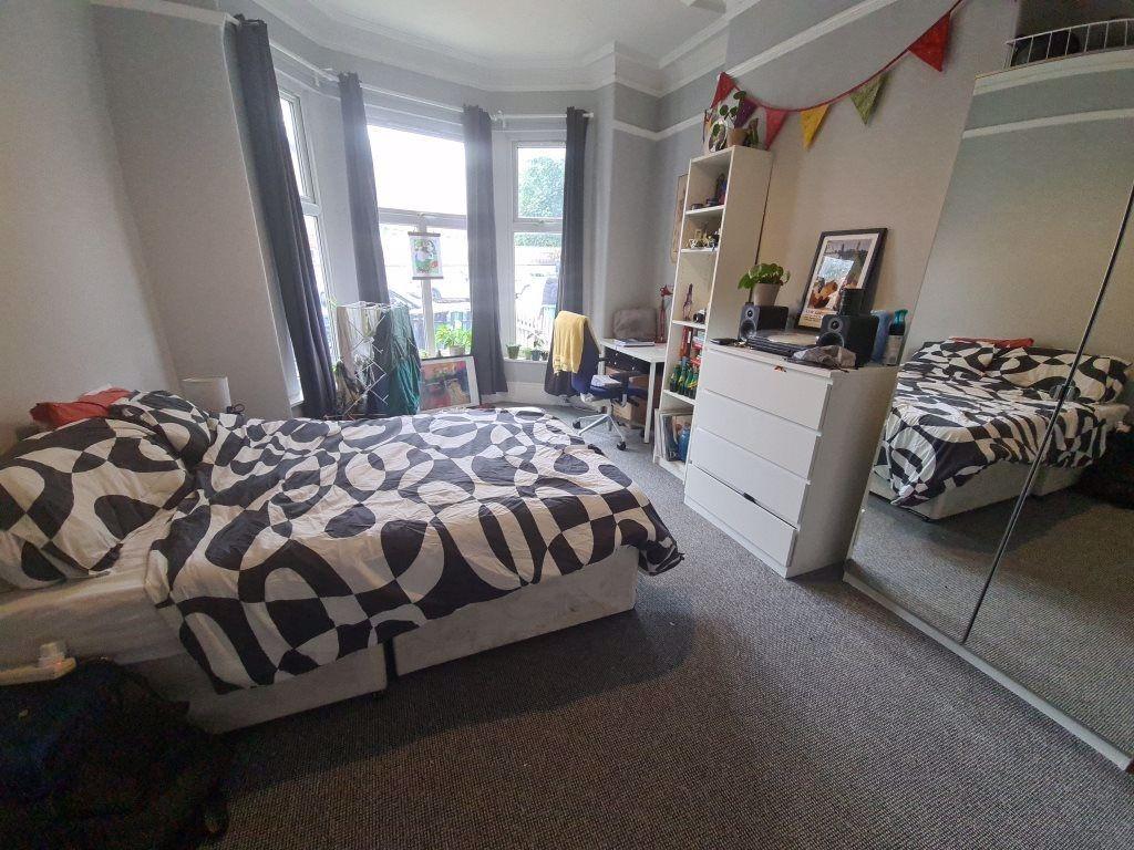 A cozy and well-lit bedroom featuring a double ...