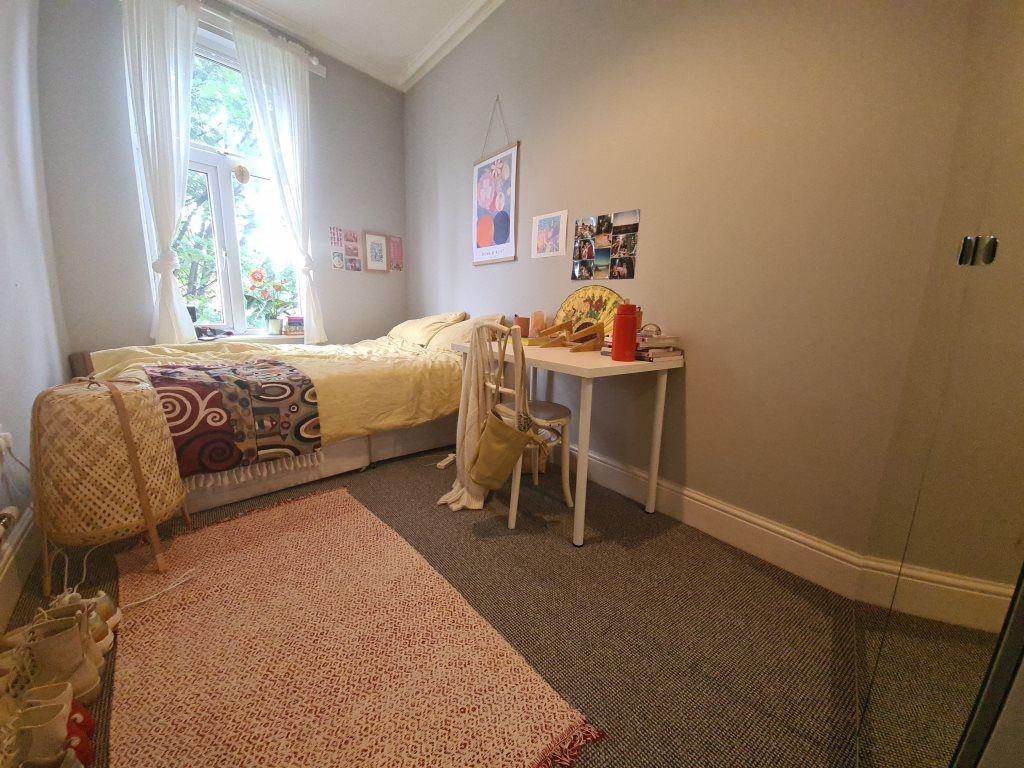 A cozy bedroom featuring a comfortable single b...
