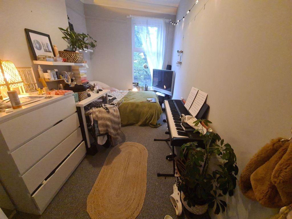 A cozy bedroom featuring a bed, a desk, and nat...