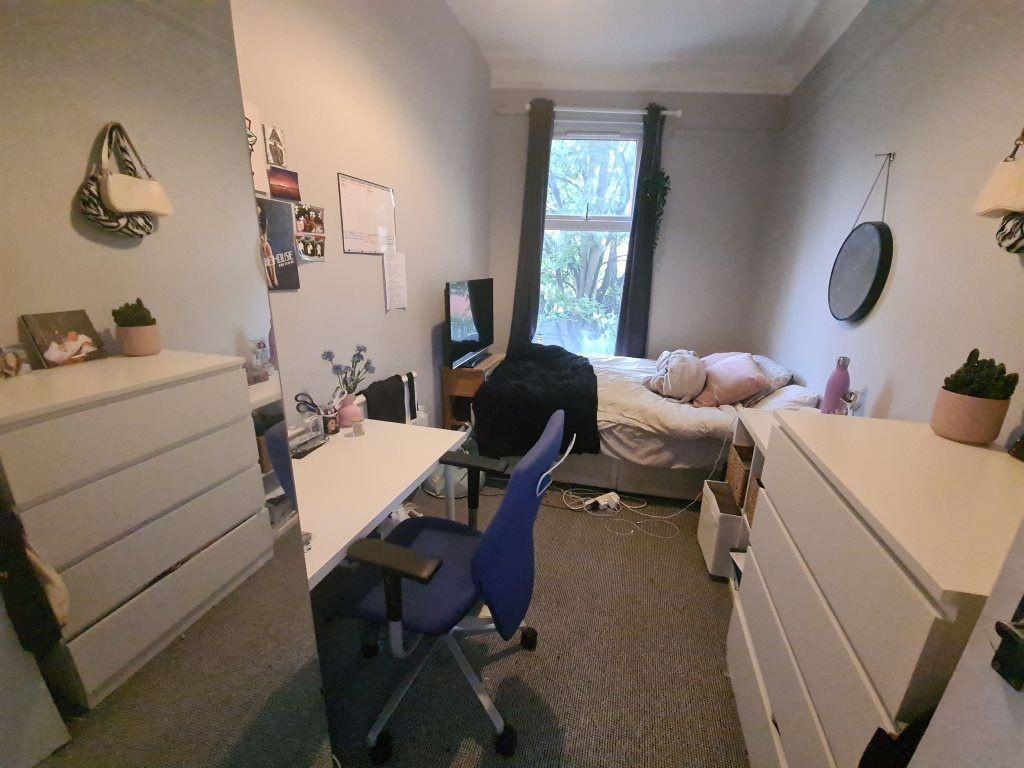 A bright and cozy bedroom featuring a study are...