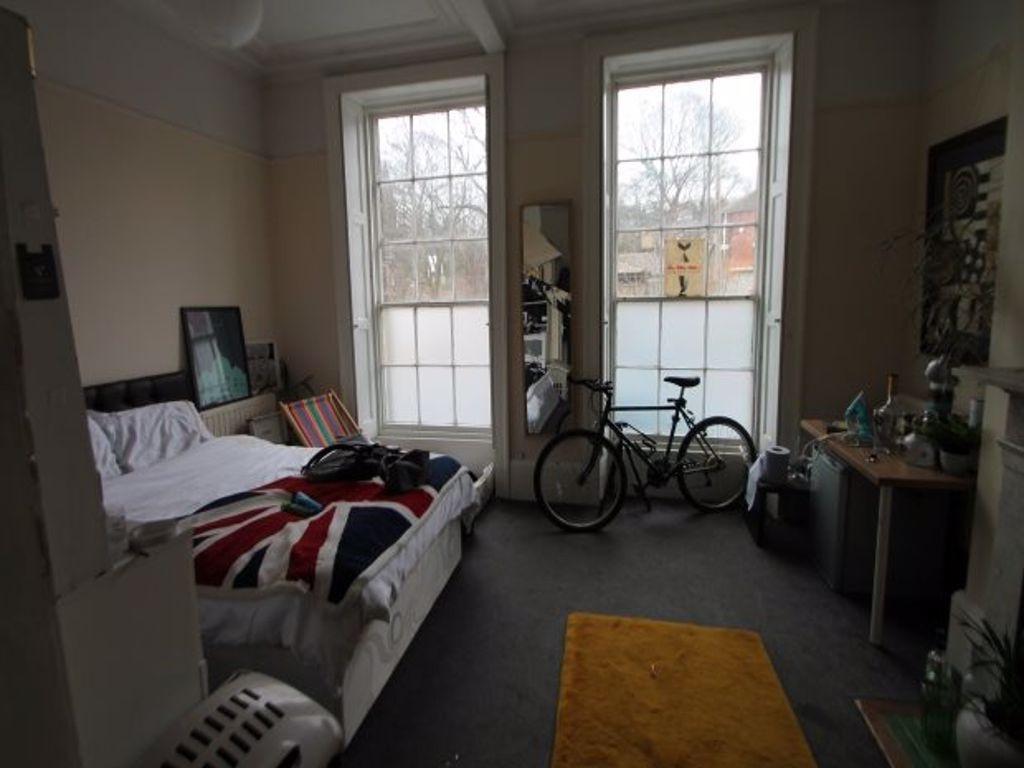 A cozy bedroom featuring two large windows that...