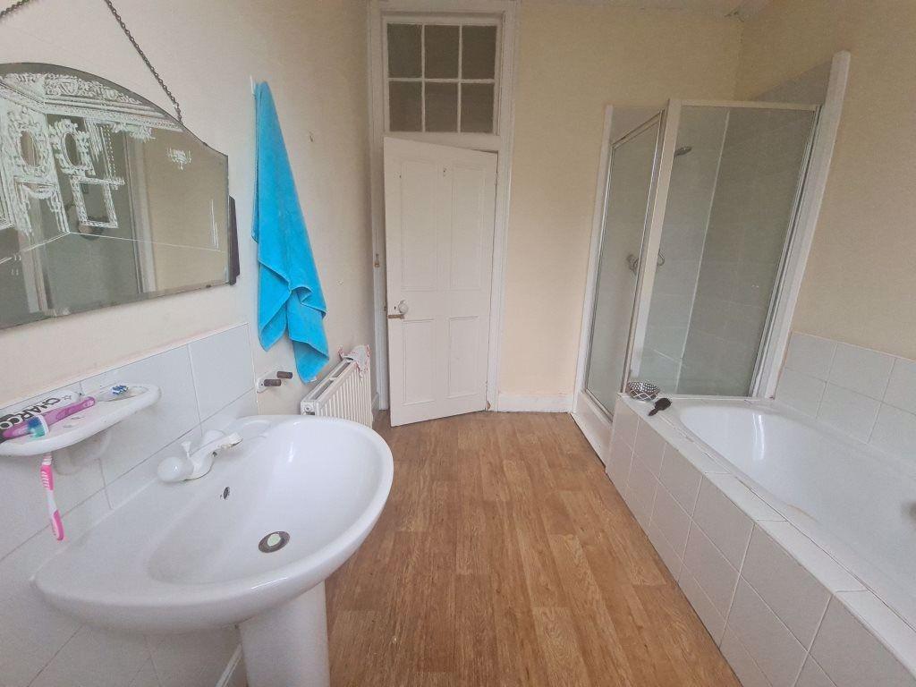 Bright and tidy bathroom featuring a modern sho...