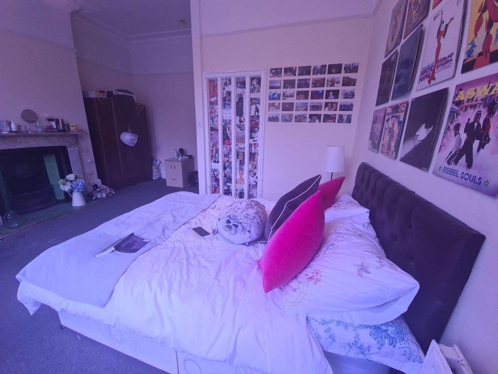 A cozy single bedroom featuring a neatly made b...