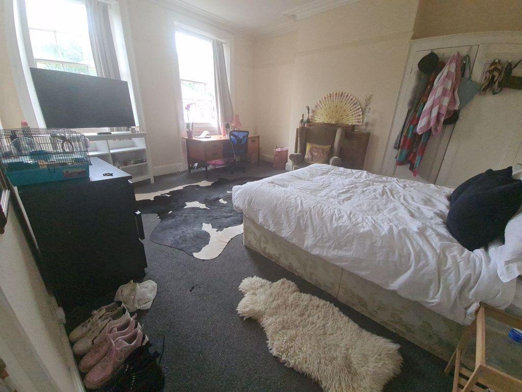 Spacious master bedroom featuring a large bed, ...