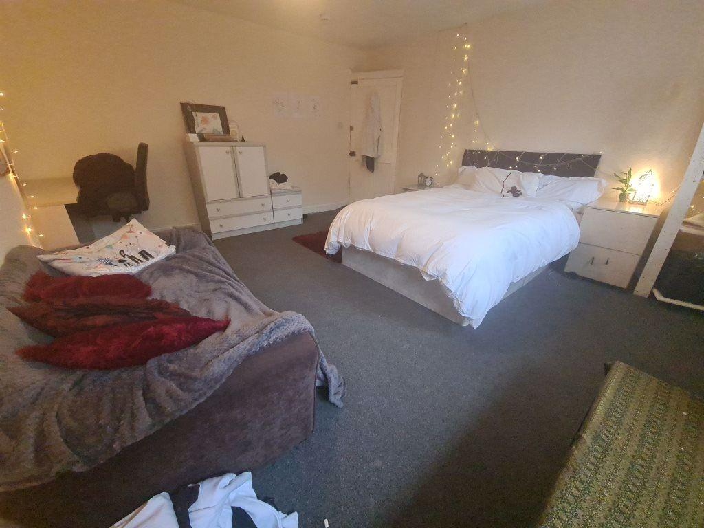 A well-maintained bedroom featuring a large dou...
