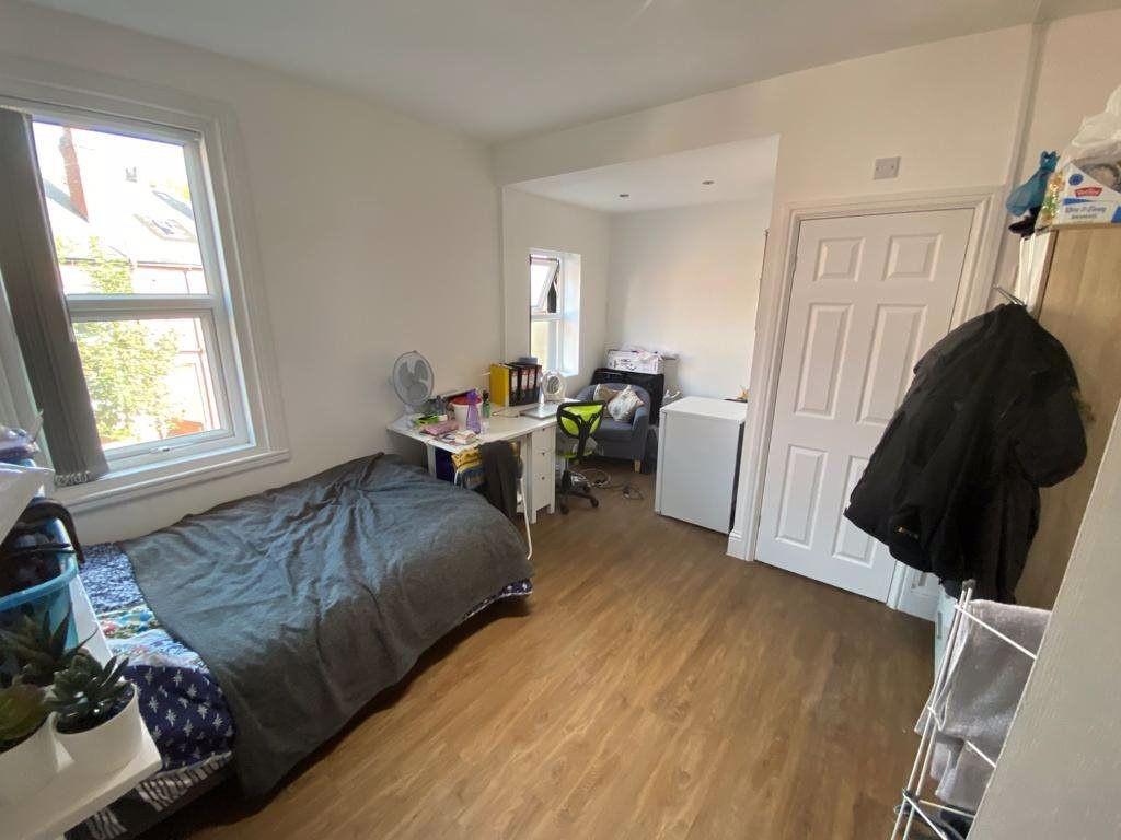 A cozy bedroom featuring a single bed, bright n...