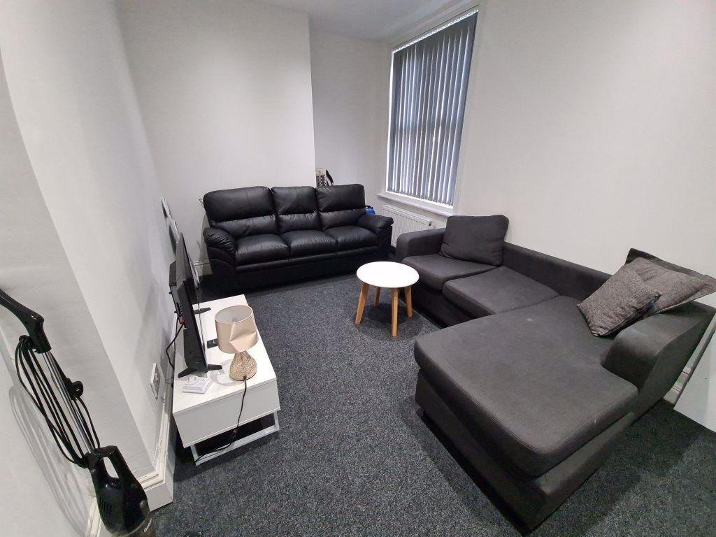 A spacious, well-lit living room featuring a co...