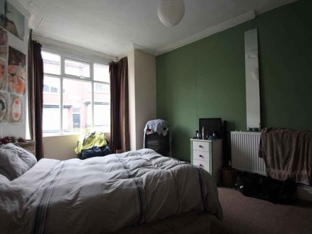 A spacious master bedroom featuring a large bed...