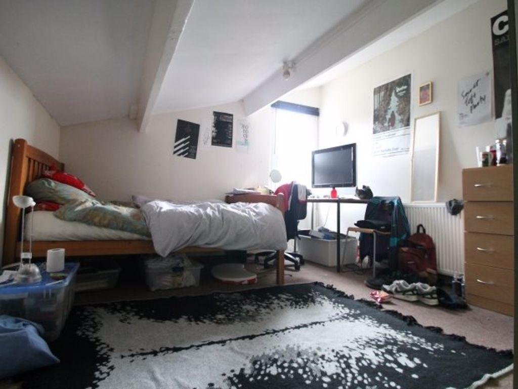 A cozy bedroom with a single bed, a desk, and a...