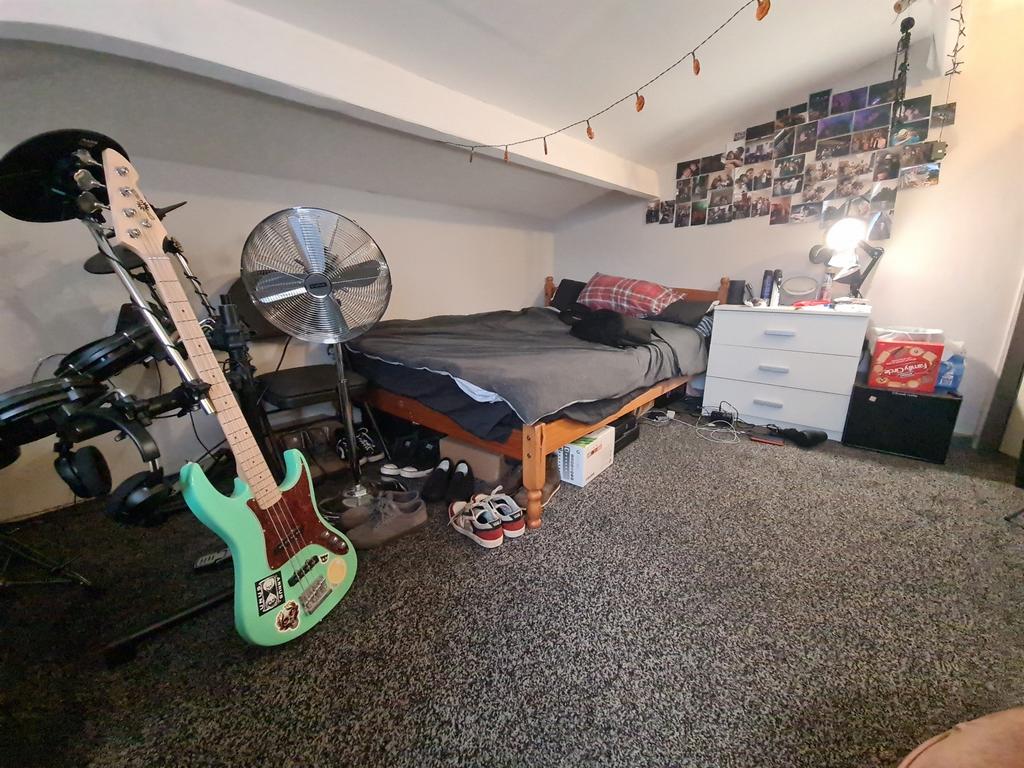 A well-used bedroom featuring a bed, musical in...
