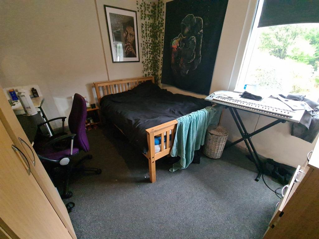 A cozy bedroom featuring a wooden bed frame, a ...