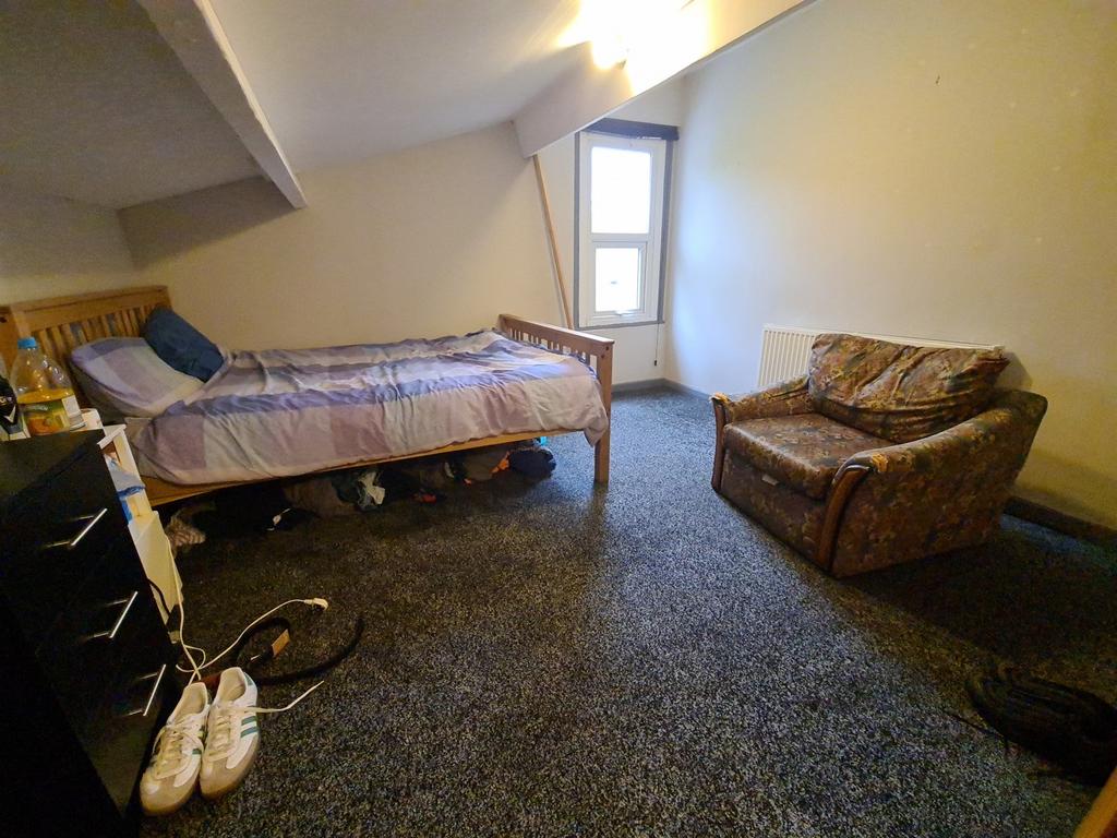 A cozy bedroom featuring a double bed, a comfor...