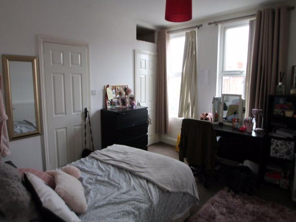 A cozy bedroom featuring a comfortable bed, a d...