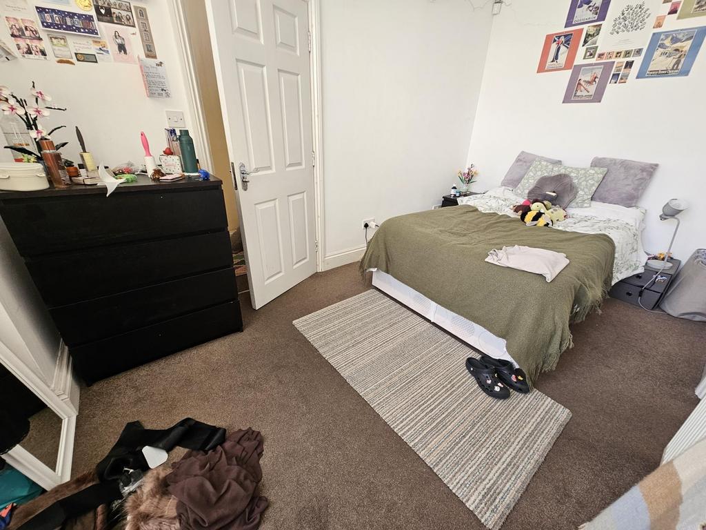 Bright, neatly arranged double bedroom with a c...