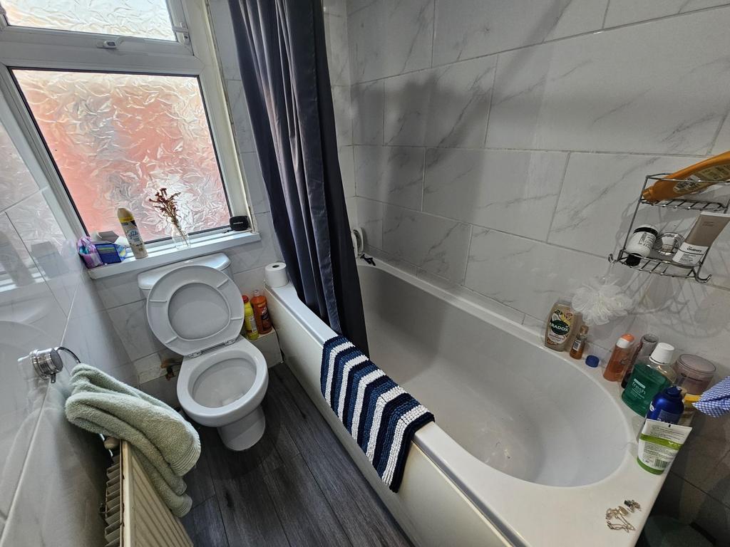 Bright, modern bathroom with a clean white bath...