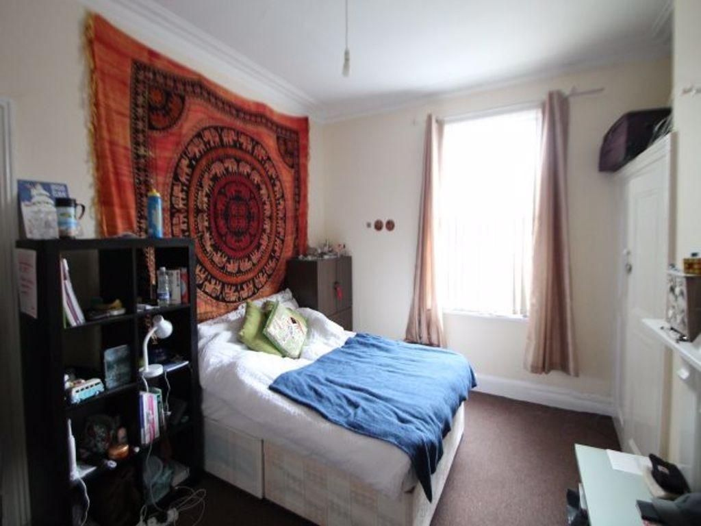 A cozy bedroom featuring a neatly made bed with...