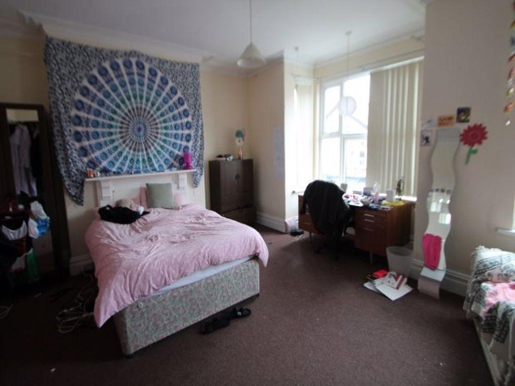 A bright and welcoming bedroom featuring a comf...