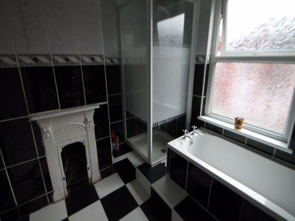 A modern bathroom featuring a bathtub next to a...