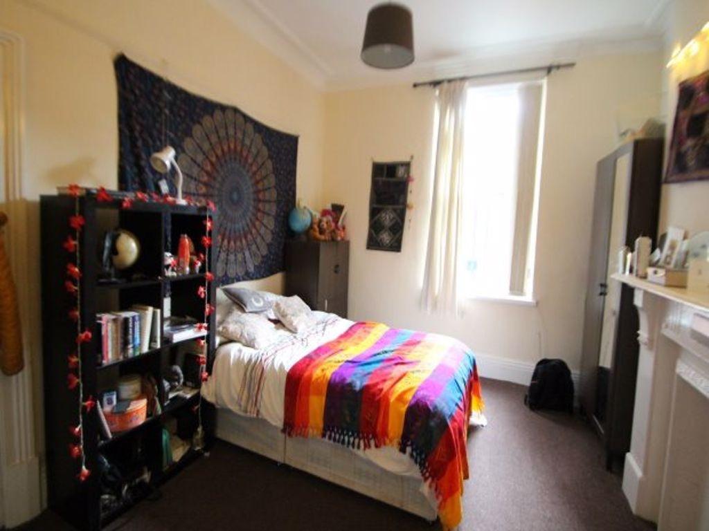 A cozy bedroom featuring a double bed adorned w...