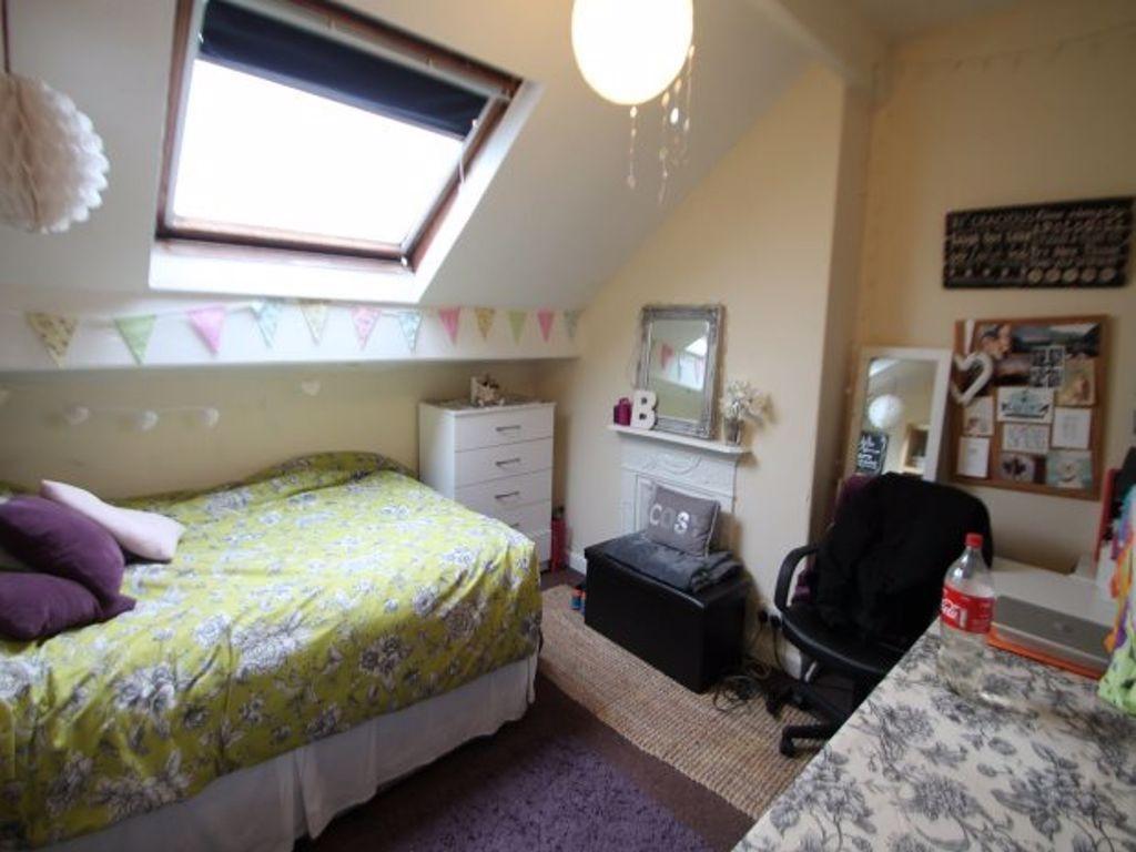 A cozy bedroom with a skylight window providing...