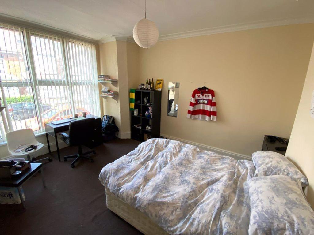 A spacious and well-lit bedroom featuring a lar...