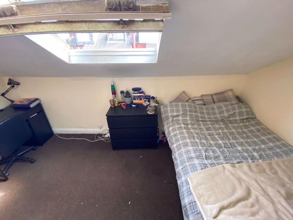 A cozy bedroom featuring a single bed with a ch...