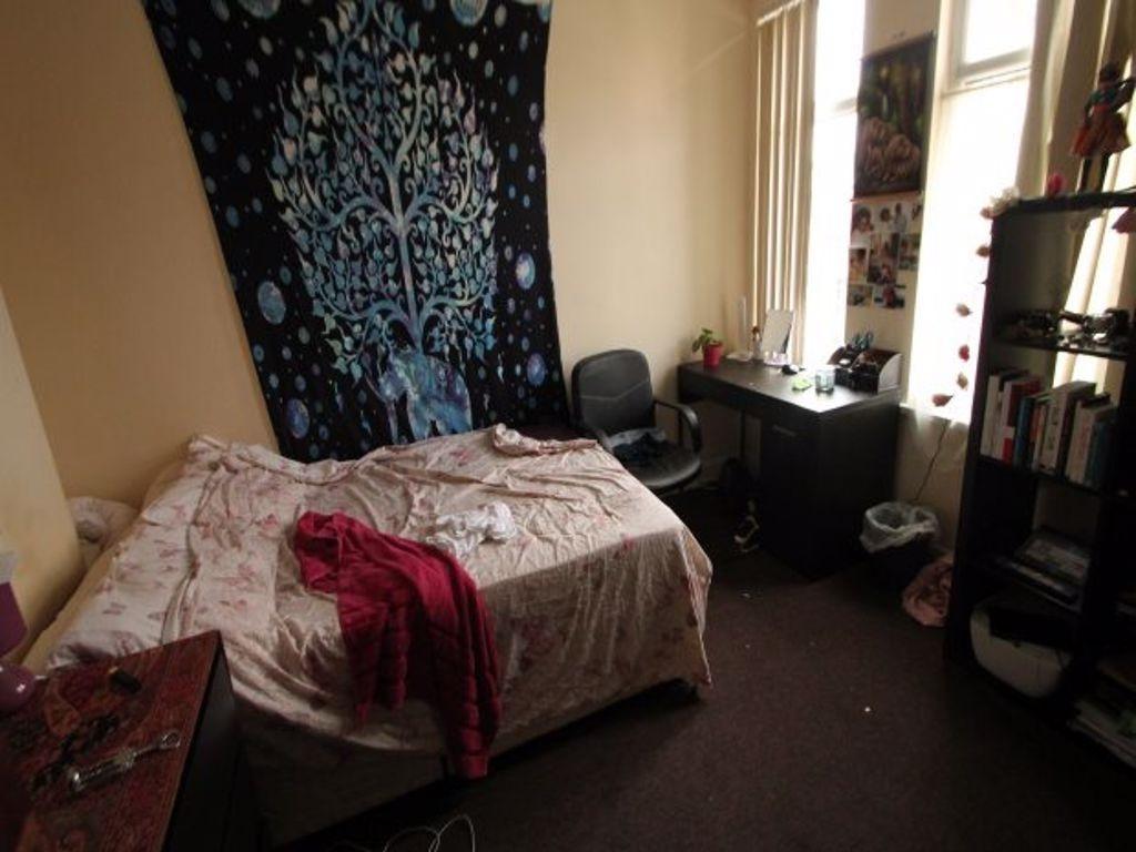 A cozy bedroom featuring a double bed with patt...