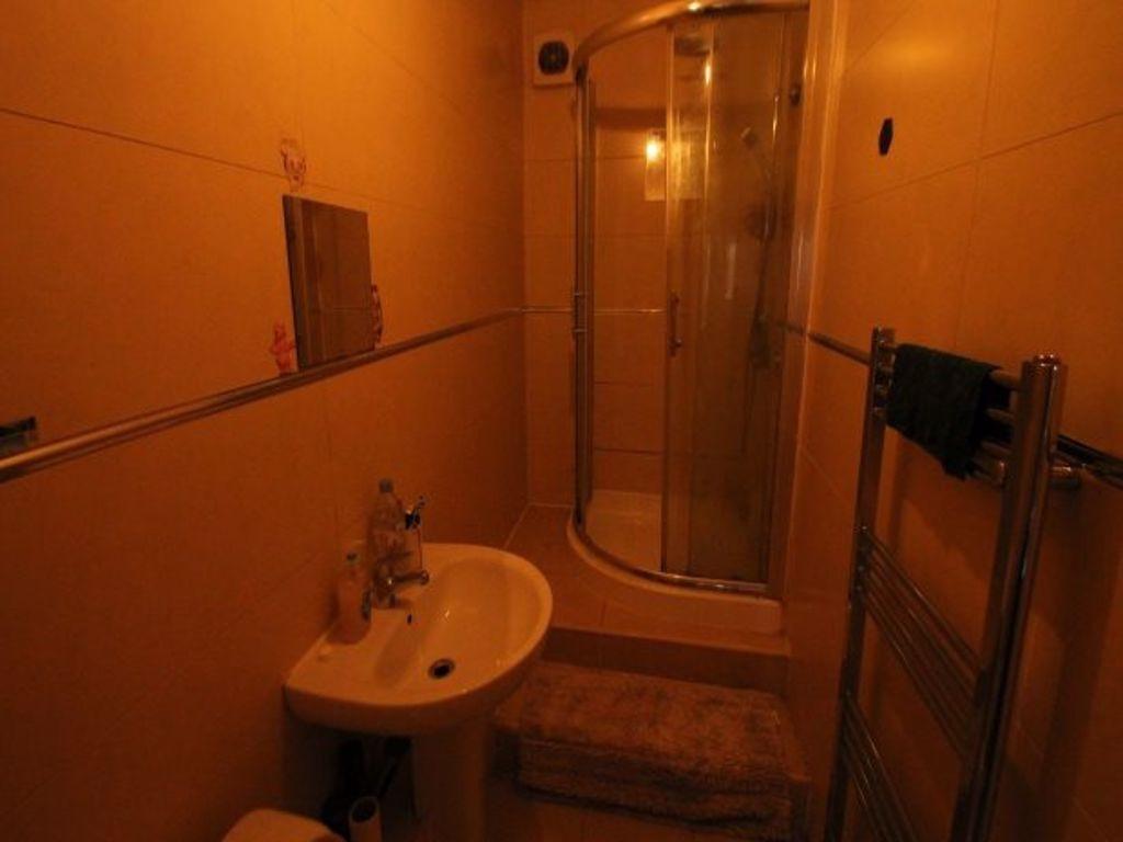 A compact bathroom featuring a shower cubicle a...