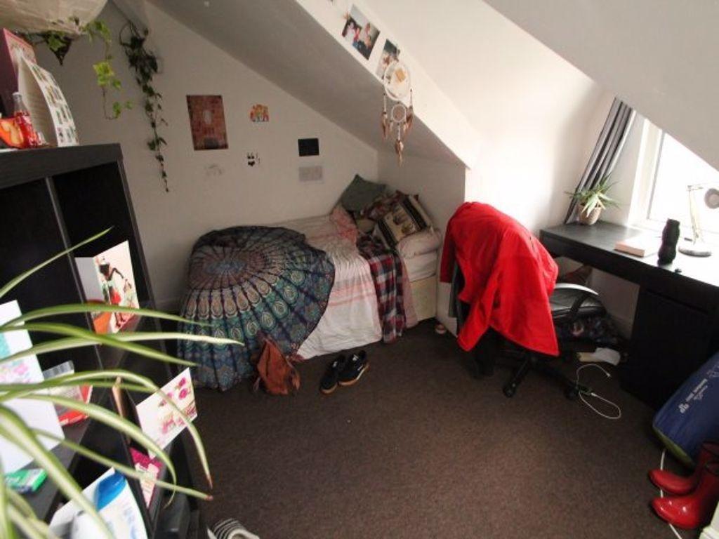 A cozy student bedroom featuring a comfortable ...