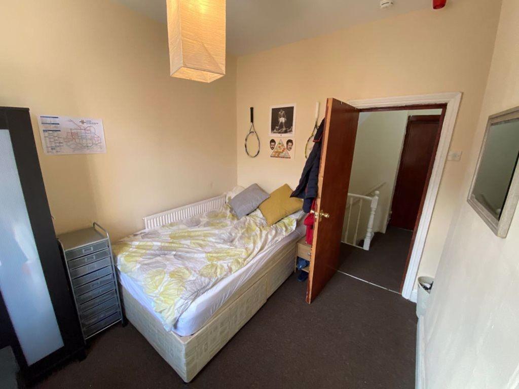 A cozy single bedroom with a comfortable bed, a...