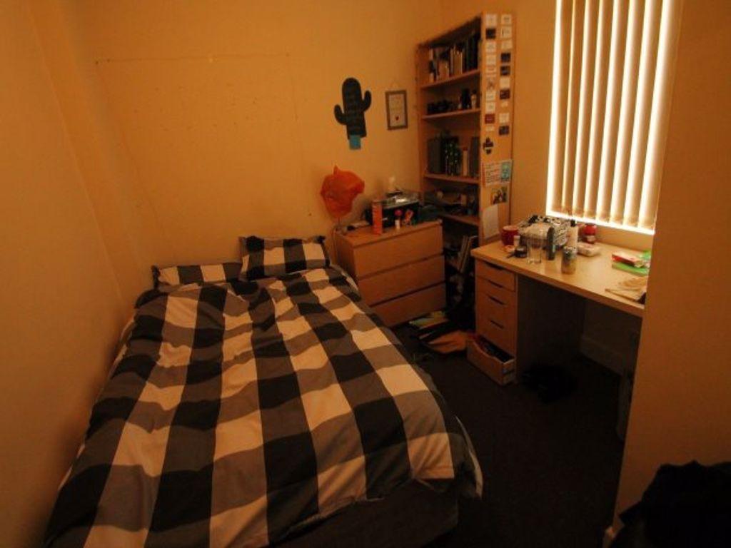 A cozy bedroom featuring a double bed, with a b...