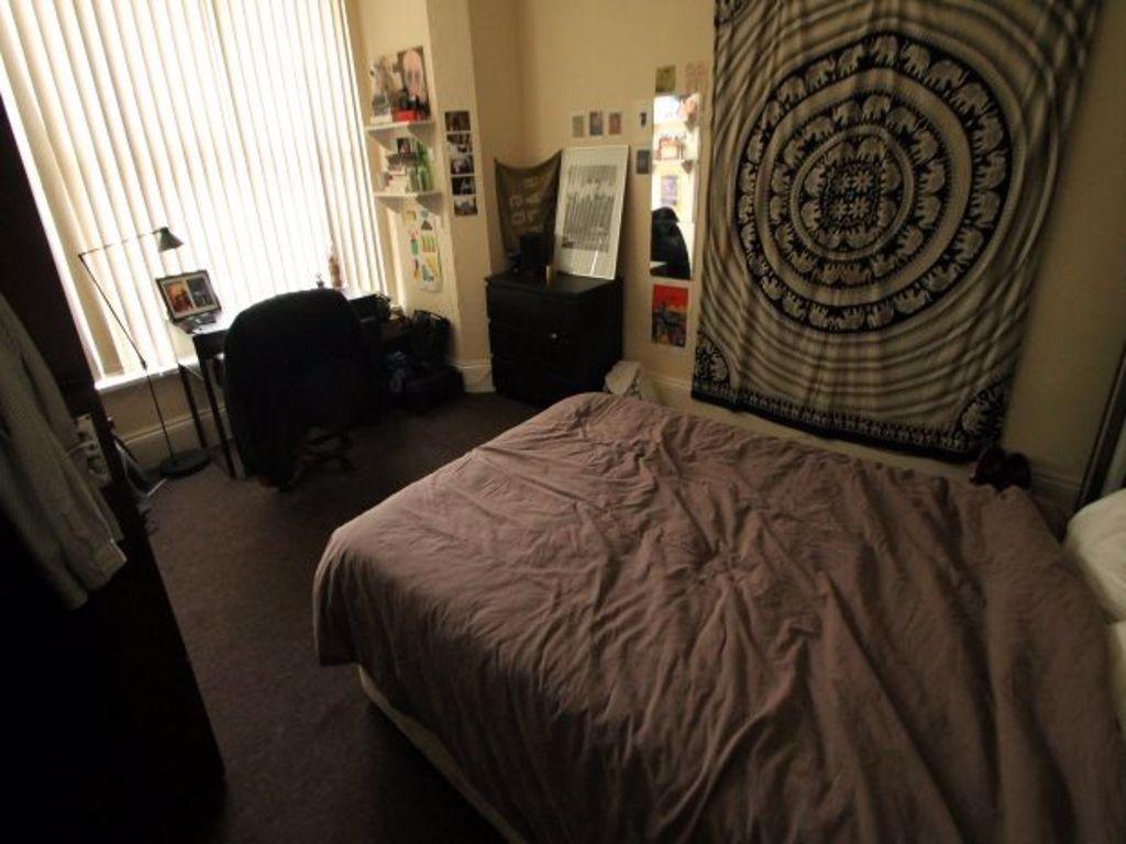 A cozy bedroom featuring a neatly made bed with...