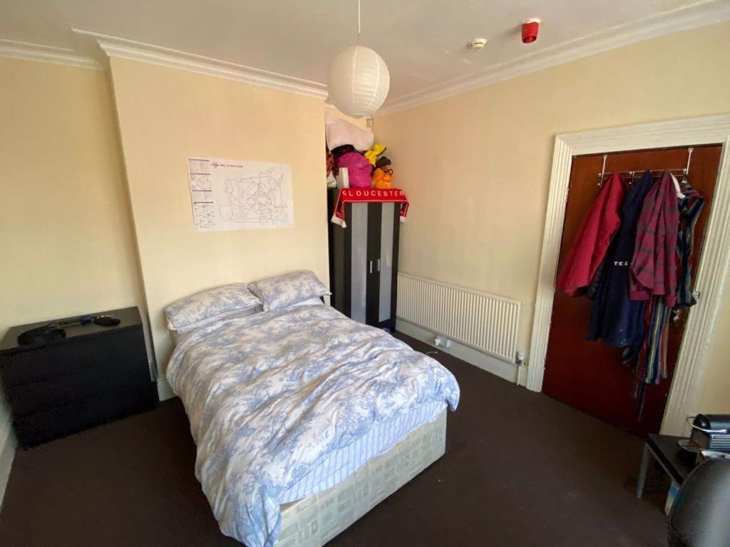 A cozy bedroom with a double bed, a wardrobe, a...