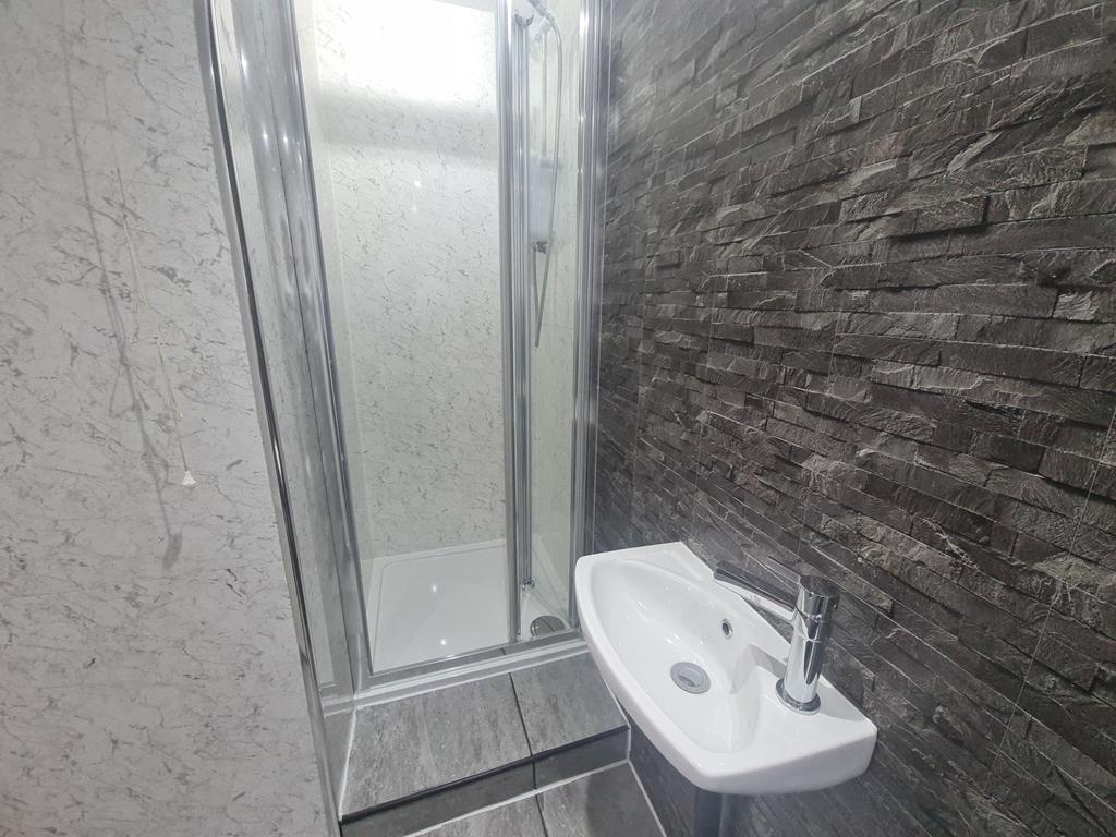 A modern bathroom featuring a spacious shower e...