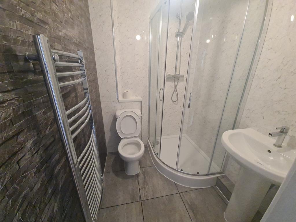 A modern bathroom featuring a curved shower enc...